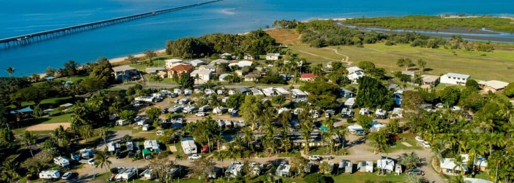 An aerial view of BIG4 Lucinda Wanderers Holiday Park, a tropical paradise near the ocean.