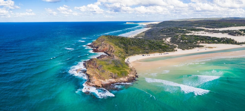 An aerial view of a beach and ocean in Sydney, New South Wales, that would be perfect for holiday park owners or inquiries.