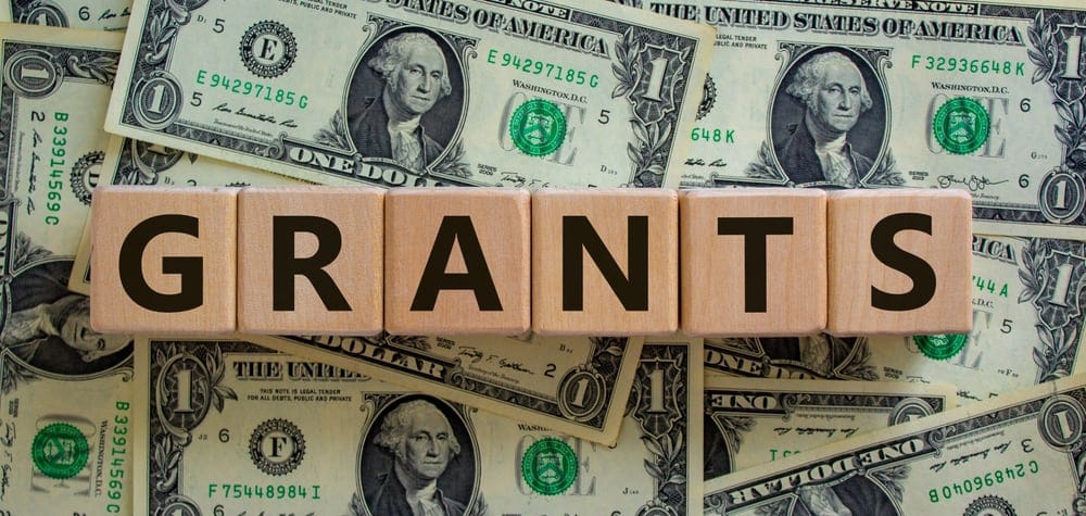 The word grants is spelled out on a pile of money, symbolizing the financial support provided by the City of Sioux City for campground development.