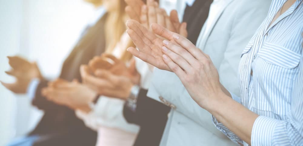 A group of business people clapping their hands.