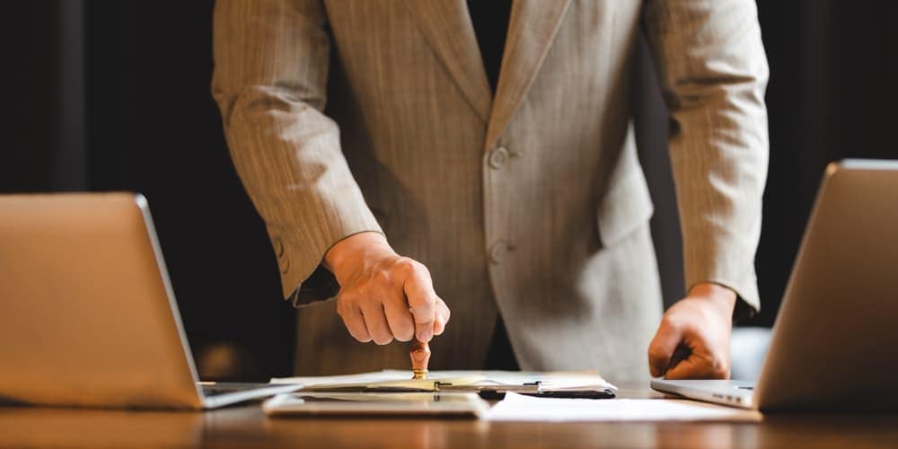 A businessman in a suit is pointing at a laptop at a campground in Henry County.