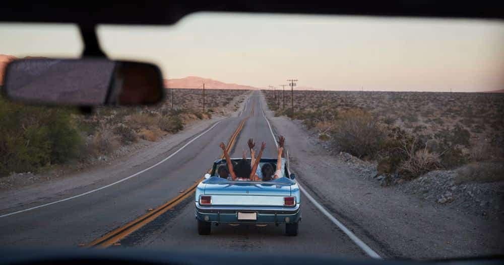 Two Americans in a car on a road trip through the desert.