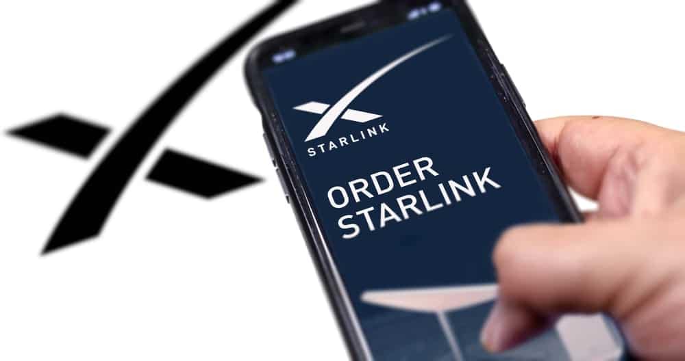 A person is holding up a phone with the Starlink app, an Affordable Alternative for high-speed internet access, displayed on it.