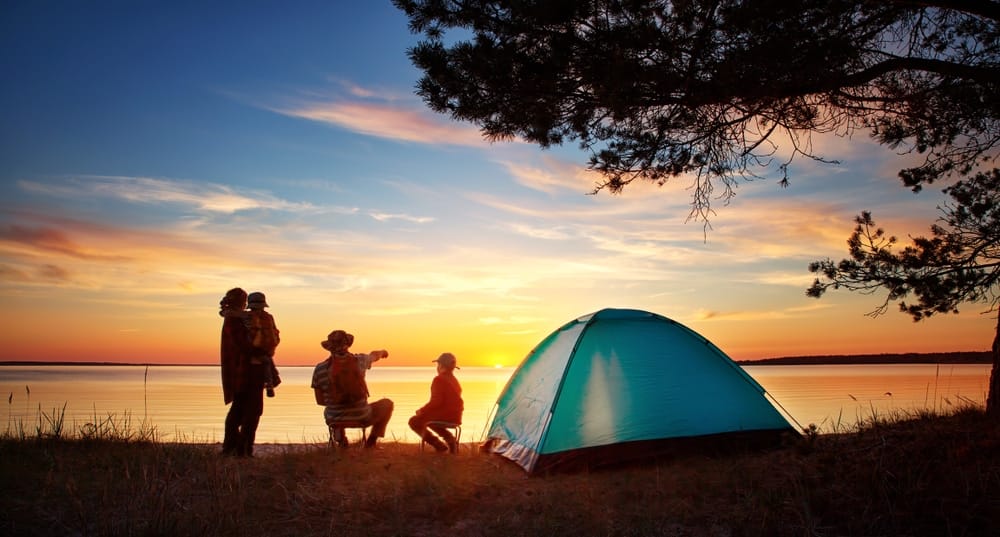 A group of people standing near a tent at sunset while participating in Camping World Holdings' earnings conference call for the third quarter fiscal 2021.