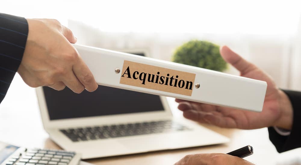 Two business people shaking hands over a document related to
acquisition in Ocean County.