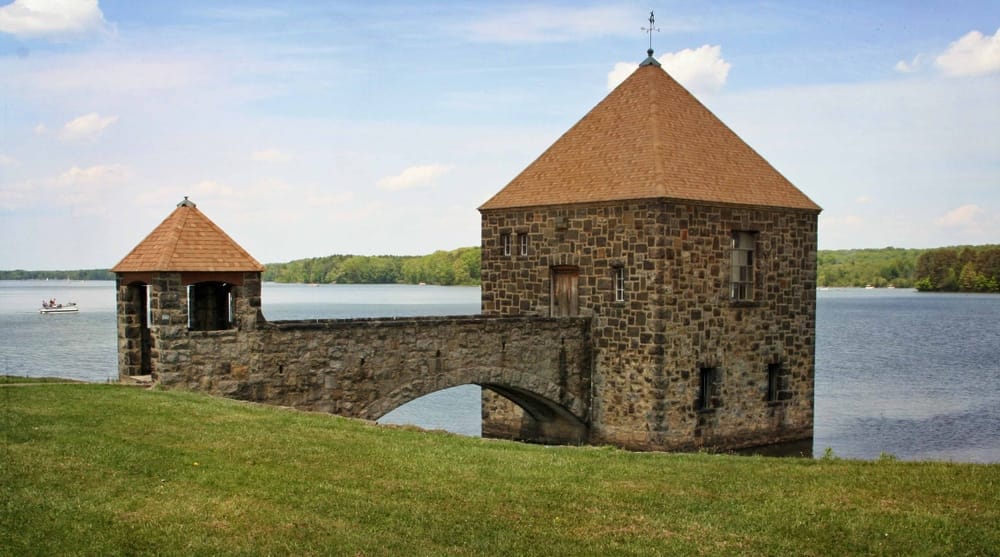 A stone tower sits next to a body of water in Pymatuning State Park.