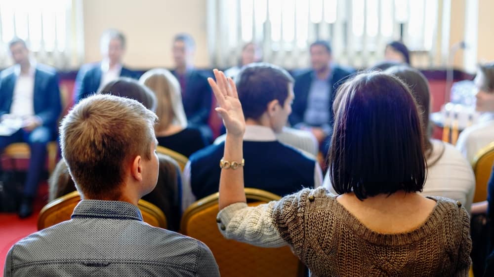 A group of people sitting in a conference room.