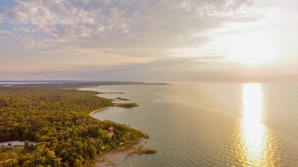 An aerial view of Timber Shores, a lake and forest at sunset.