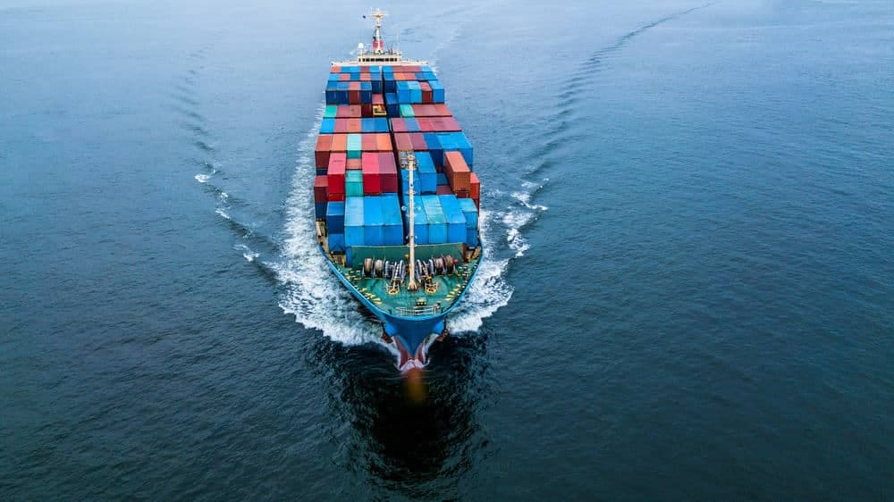 An aerial view of a container ship in the ocean, crossing through waters affected by the USTR, Section 301 China Tariffs.