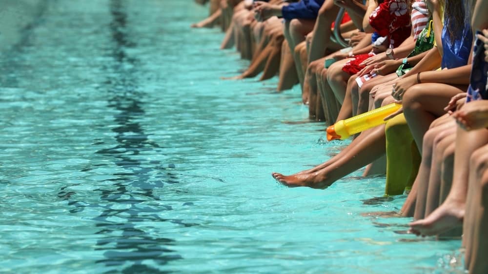 A group of people enjoying a refreshing swim at a pool in Freshwater Holiday Park.