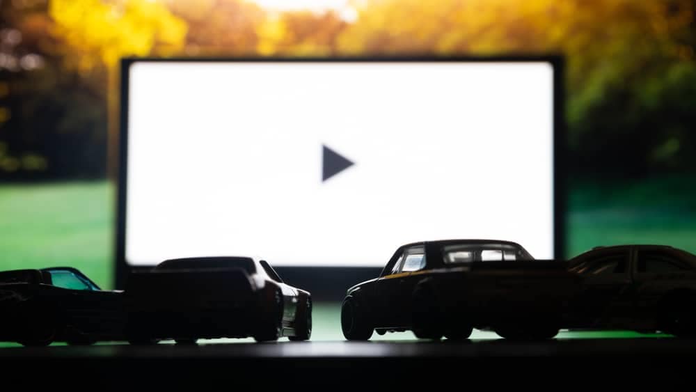 Toy cars in front of a TV screen in Alberta City.