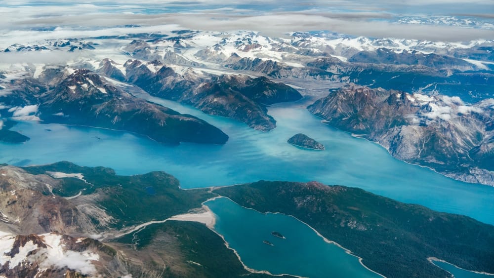 An aerial view of a lake and mountains in Alaska.