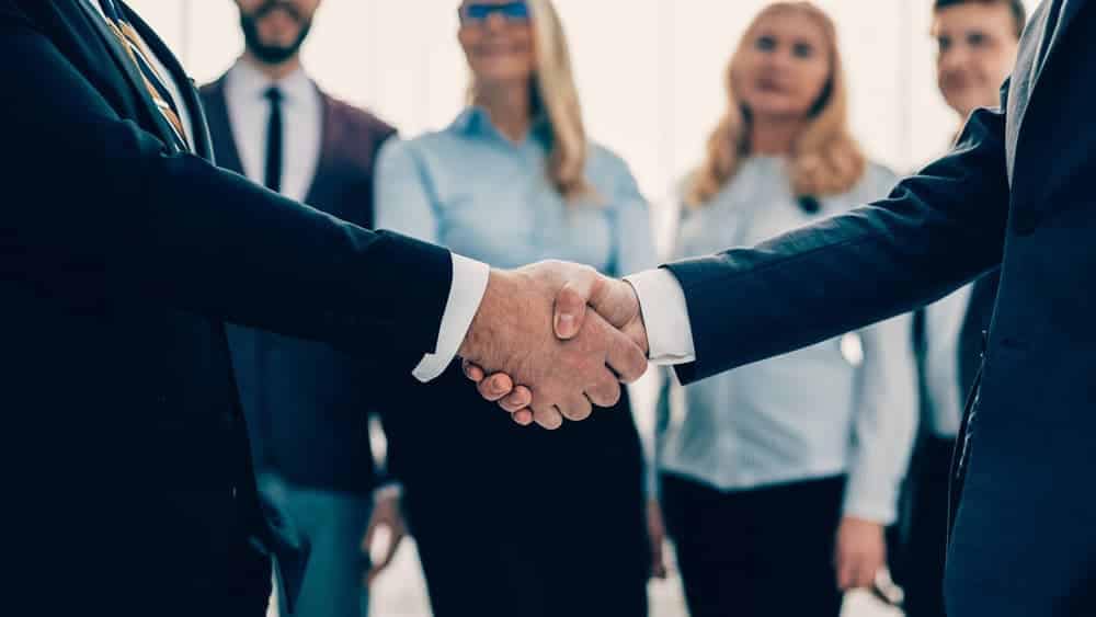 Tim Schultz, VP of Innovation at Lippert, shaking hands with a group of business people.