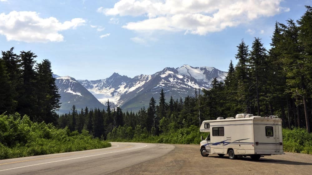 An RV parked at a campground with mountains in the background.