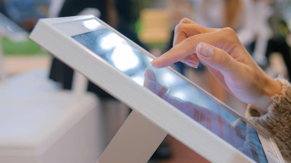 A nomad woman is using a wireless internet enabled tablet pc in a store.