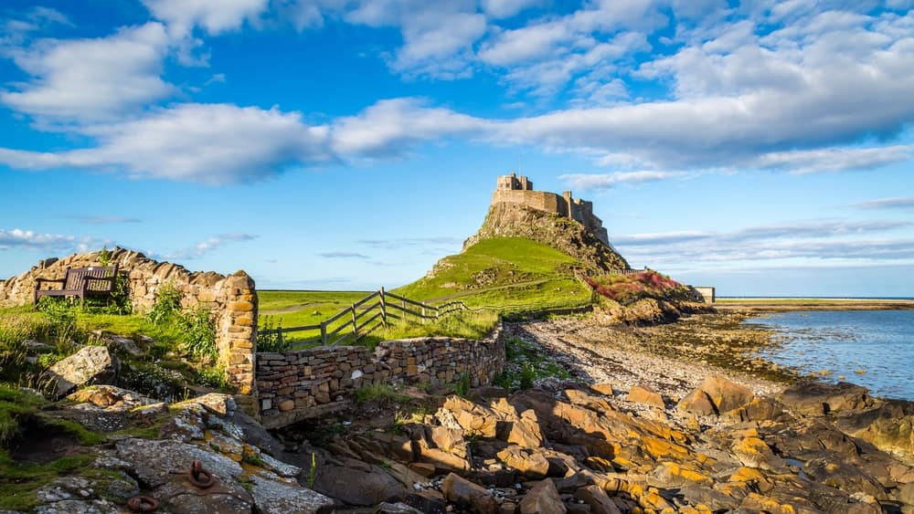 A castle on top of a hill overlooks the ocean, now under new ownership in the UK Caravan Sector.