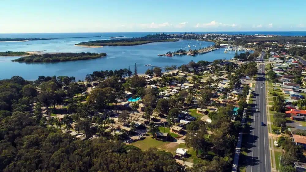 Yamba's Premier Destination for Family Vacations - An aerial view of an area with houses and water.