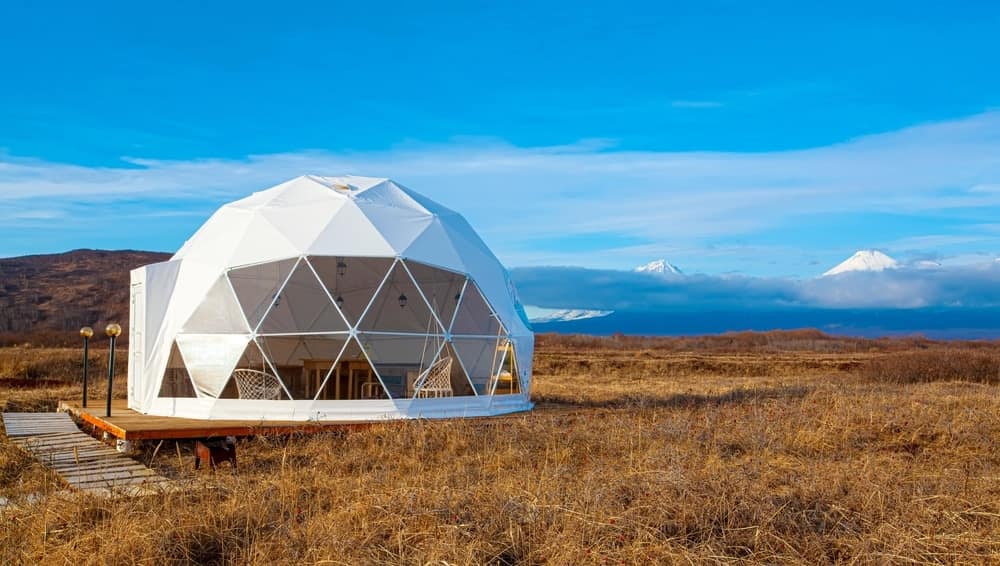 A TruDome revolutionizing the glamping experience in Japan, nestled amidst a picturesque field with majestic mountains as its breathtaking backdrop.