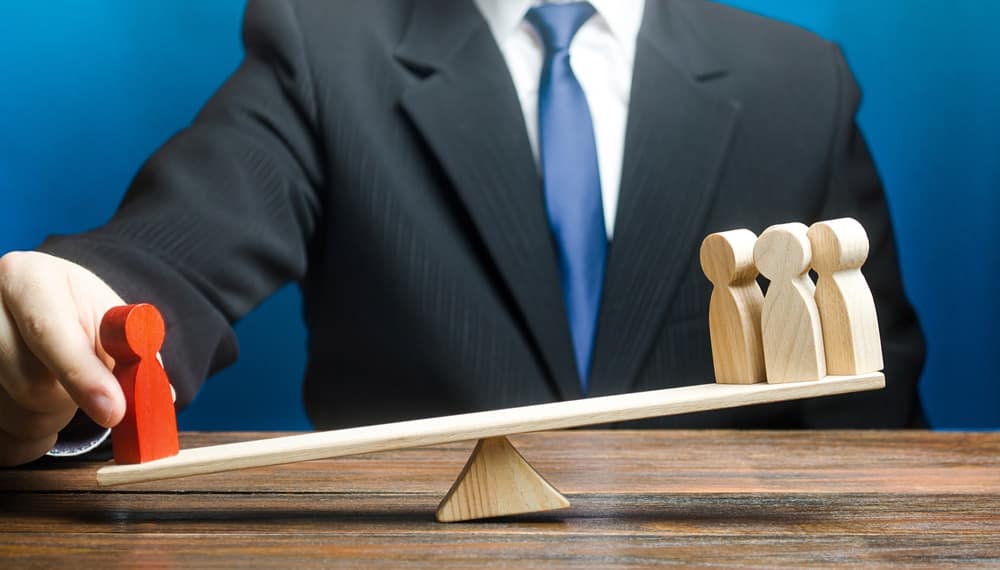 A businessman in Strathcona County is balancing two wooden figures on a seesaw while opposing the concerns of residents.