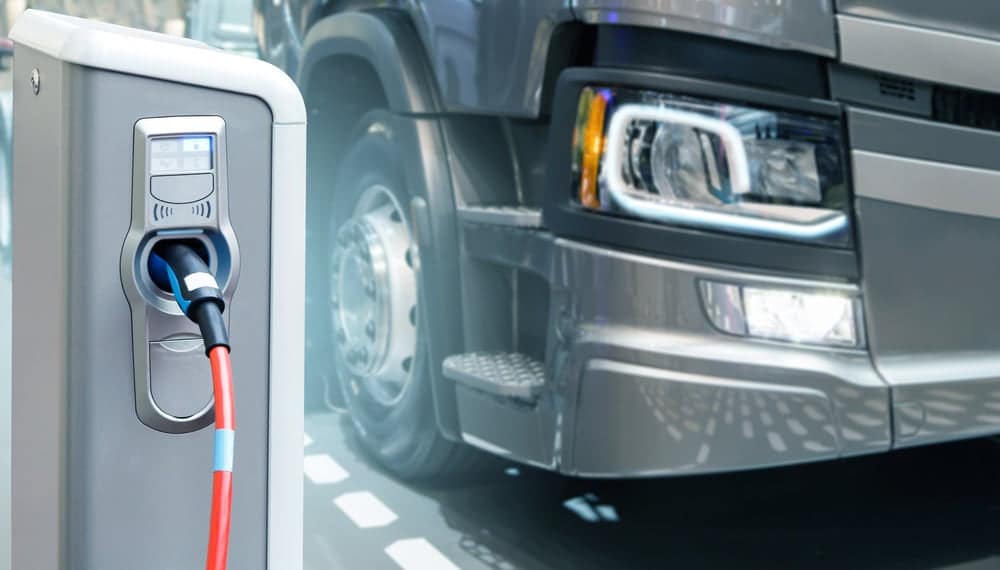 An electric truck is connected to a charging station during Electric Vehicles Work Truck Week 2022.