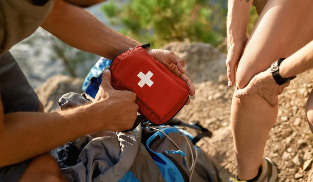 A man from New England is helping a woman with a first aid kit.