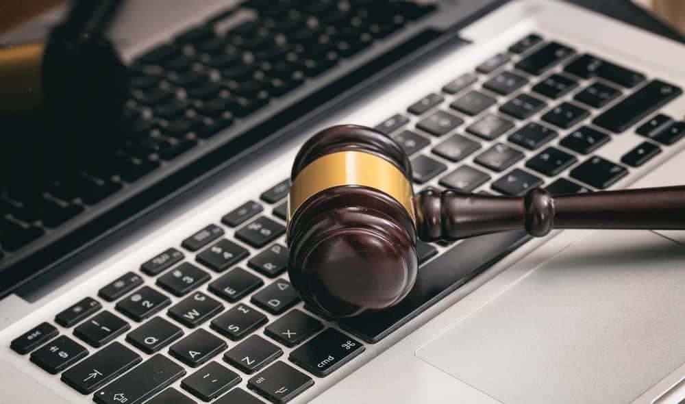 A wooden gavel sits on top of a laptop, symbolizing the Auction Donations or the March Conference organized by CCRVC.