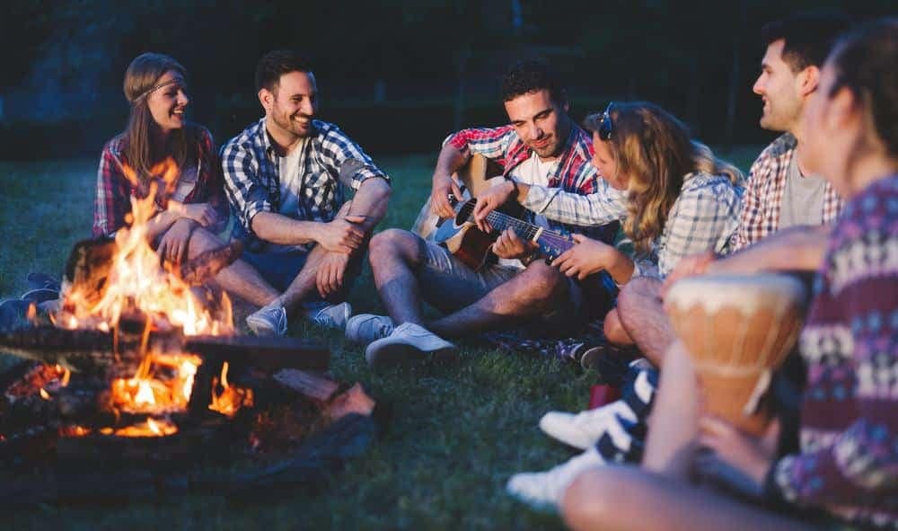 A group of friends adapted to the pandemic by sitting outdoors around a campfire in the sun.