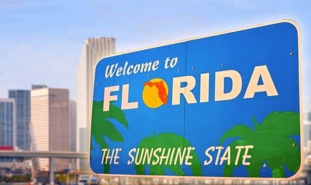 A welcome sign in front of a city in Florida, inviting visitors to explore the vibrant destination.