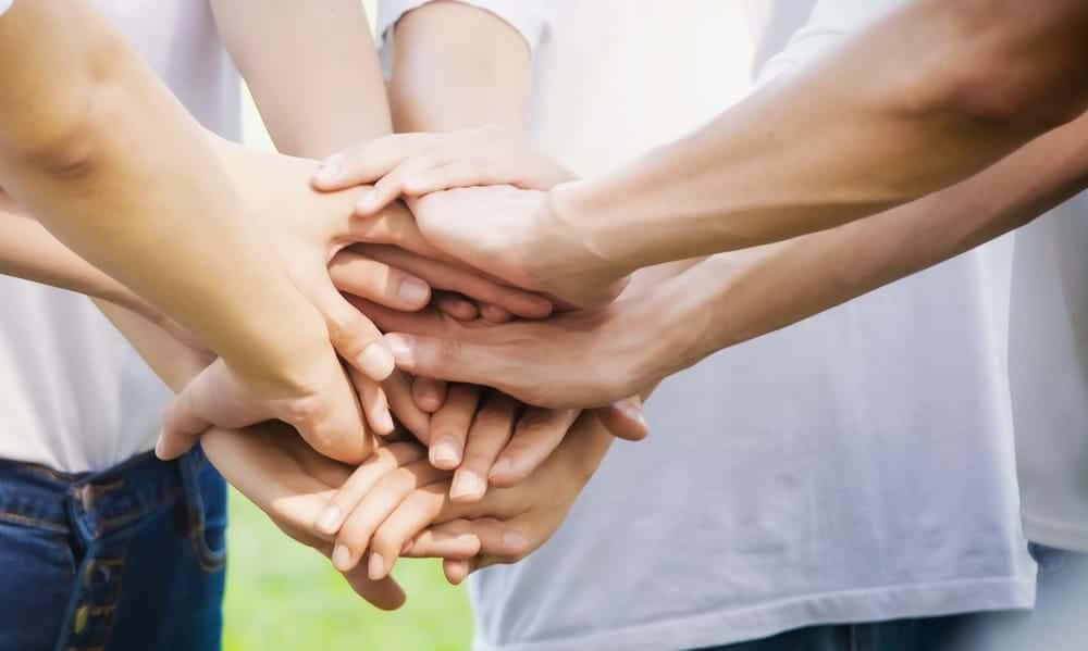 A group of people coming together, showing unity and cooperation.