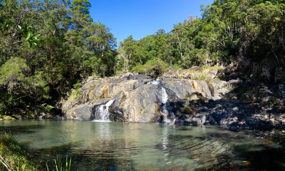 Upgrade the scenic landscape of Booloumba Creek with a stunning waterfall nestled amidst lush trees and rugged rocks. Campers will be enchanted by the natural beauty of this picturesque site.
