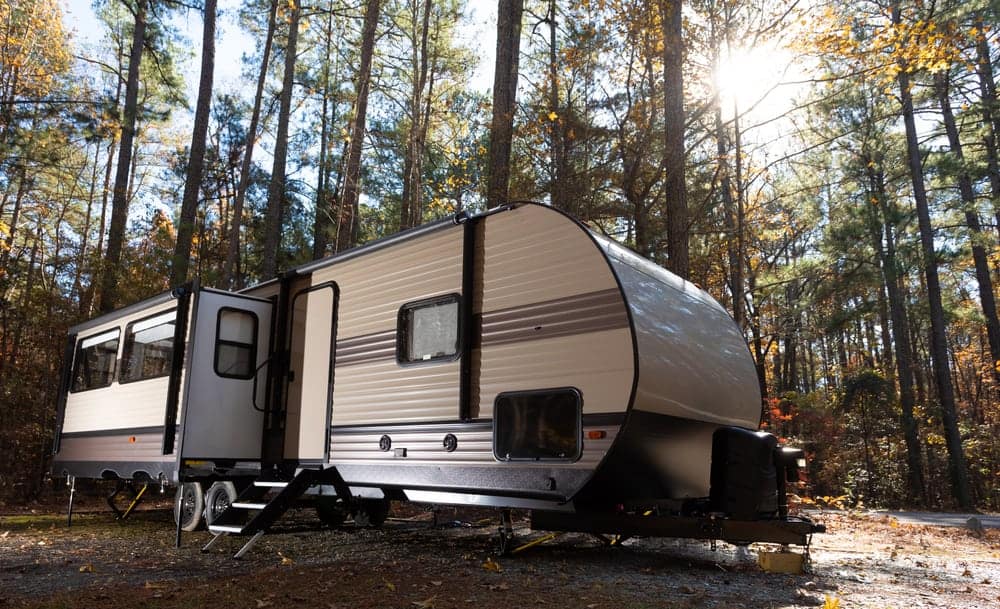 A Lippert RV with a Keyless RV Door Lock parked in the woods.