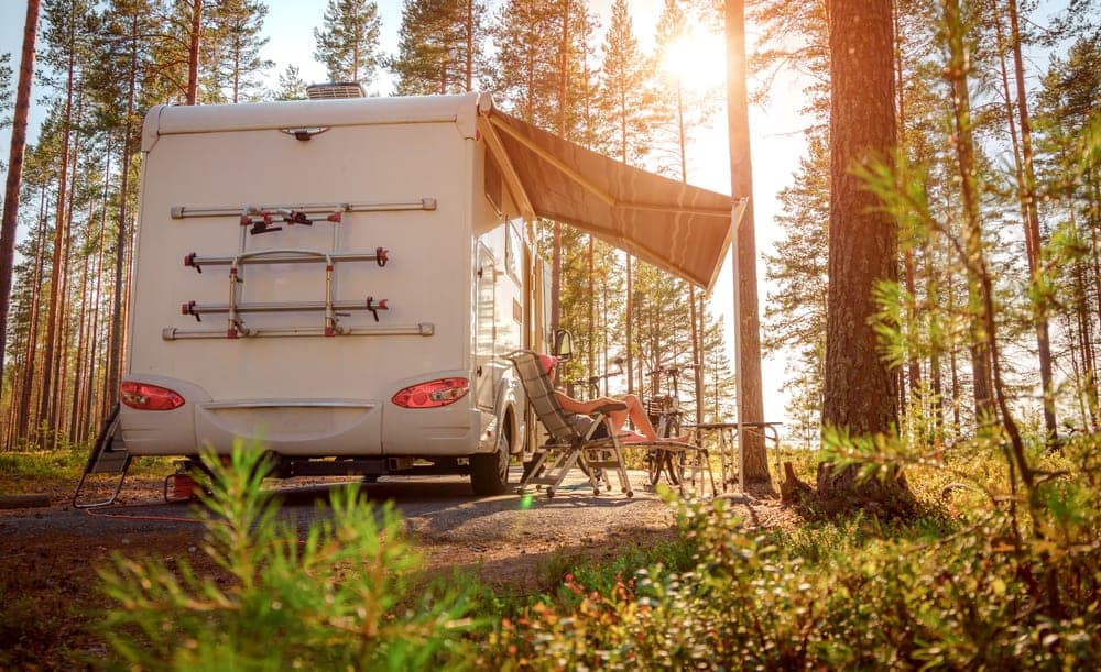 A profitable RV rental parked in a serene forest setting, providing a delightful experience for both RV owners and nature enthusiasts.
