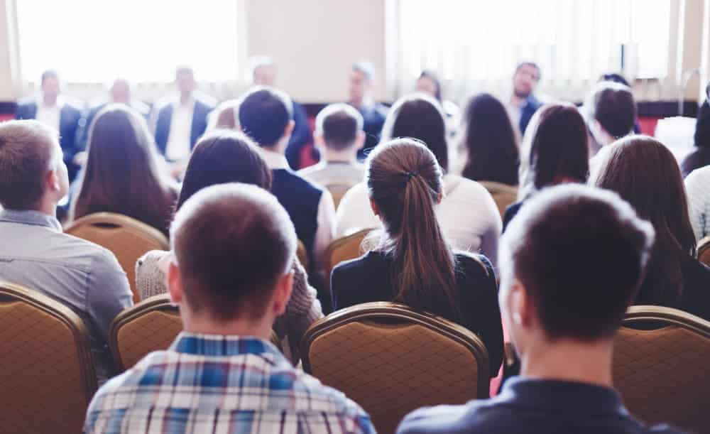 An annual conference where people gather in a conference room to learn and network.