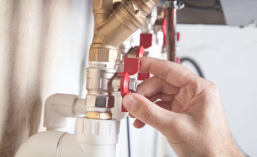 A skilled man, certified by the Victorian Building Authority, diligently attends to a water heater repair project in a bathroom. With his expertise in gas safety, he ensures that the task is completed efficiently