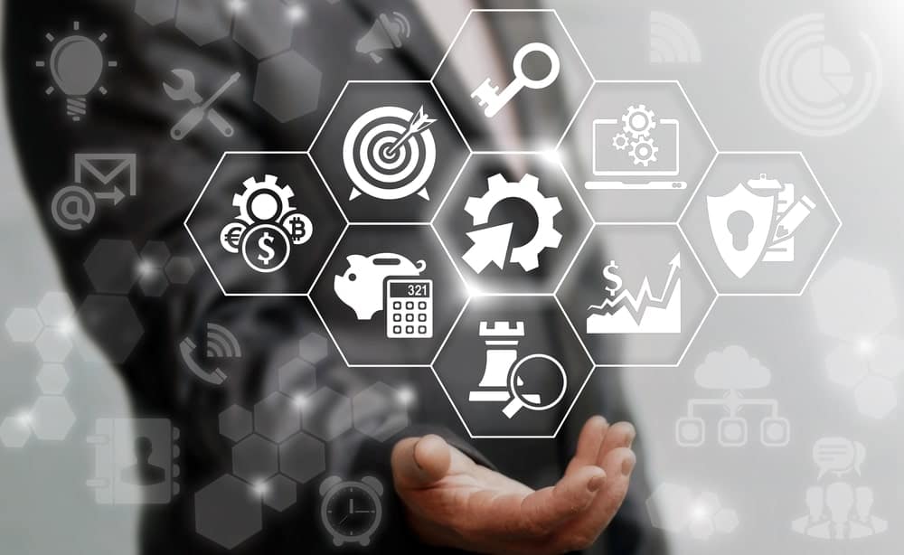 A businessman is holding a hand full of business icons related to the White Pine Digital campsite booking platform developed by Northgate Resorts.