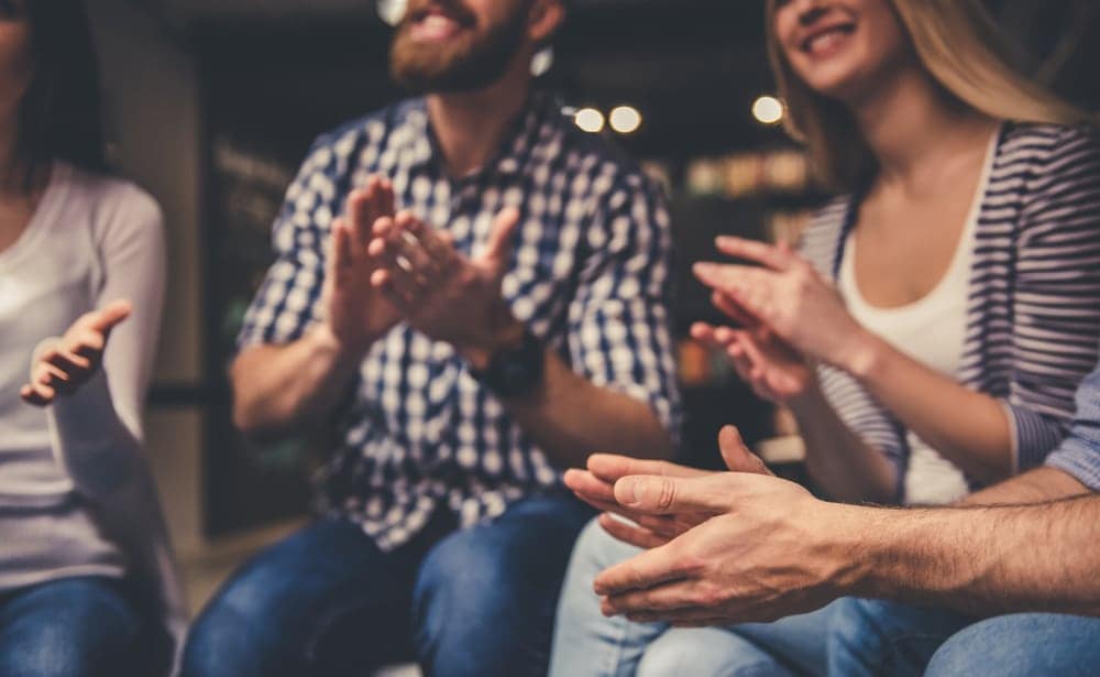 A group of owners clapping at an expo party.