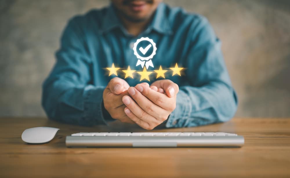 A certified RV industry expert holding a laptop with a five star rating on it.