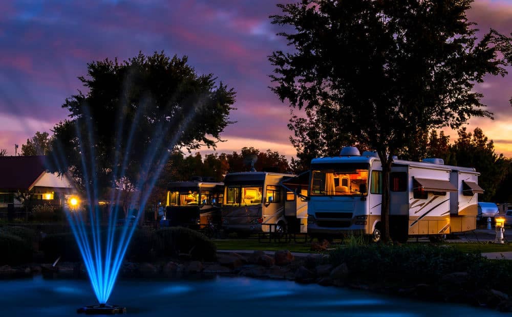 Luxury RV resort at dusk with a fountain and RVs in Ouachita Parish.