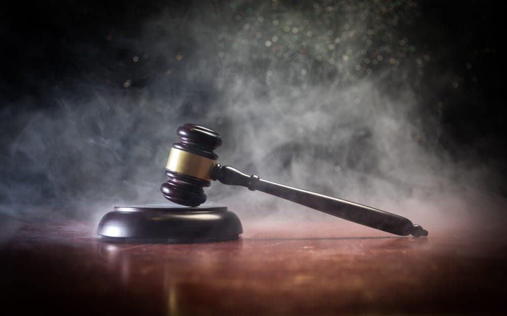 A judge gavel on a table with smoke coming out of it in a campground development in Maine, where stricter rules are being enforced.