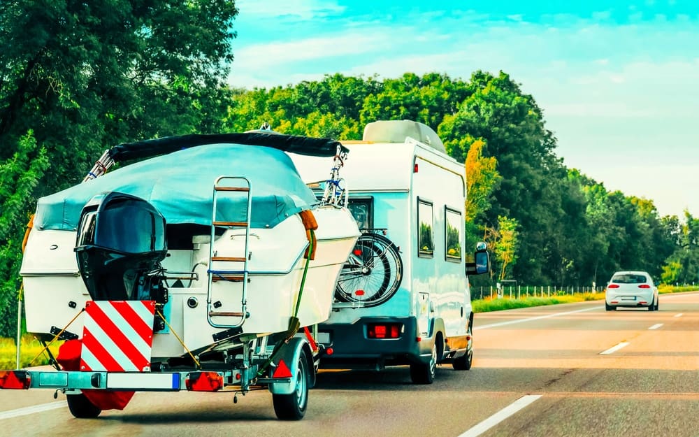A trailer accompanies an RV as it journeys through the road.