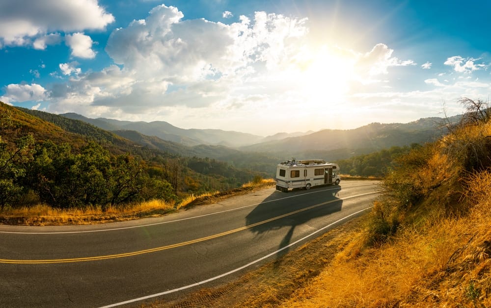 An rv traveling down a winding road in the mountains.