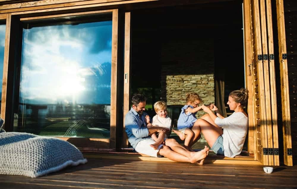 A family enjoys their AU$2M cabin investment on the deck of their home at Reflections Holiday Park, a Travelers' Choice 2022 destination.