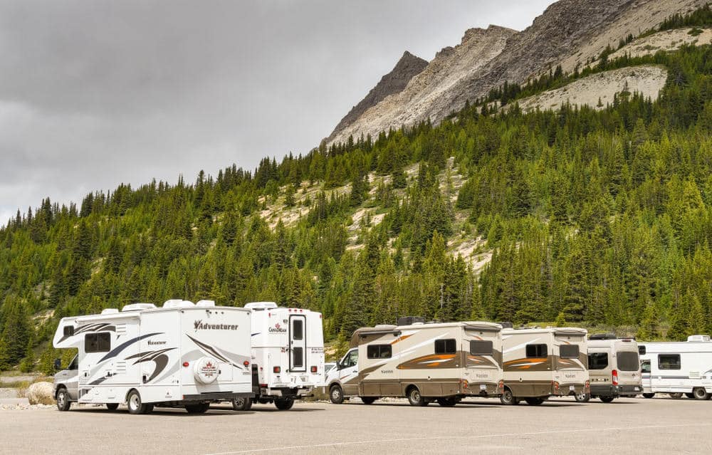A new supercenter of General RV Center, with a group of rvs parked in front of a majestic mountain.