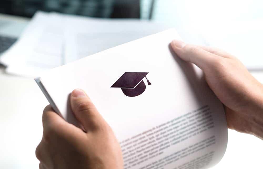 An Office Manager proudly displays a paper adorned with the graduation cap symbolizing their achievement as a recipient of the Mike Molino RV Learning Center Scholarship through World Wide RV.