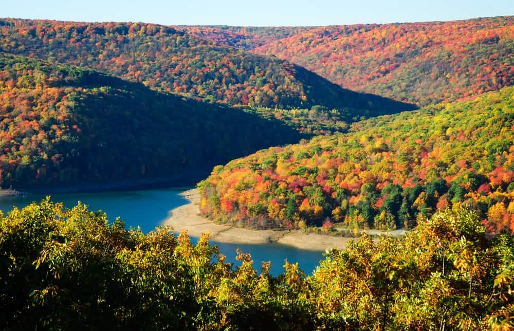 A view of Dewdrop Campground with colorful fall foliage surrounding a serene lake.
