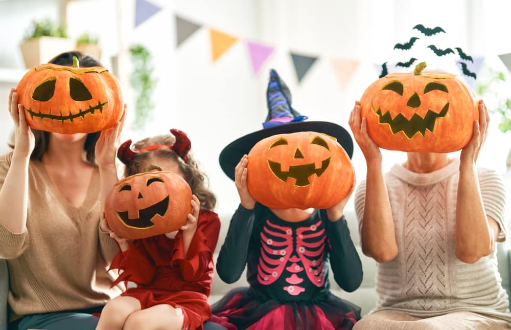 A group of people holding pumpkins in front of them during a Halloween celebration at Verde Ranch RV Resort.