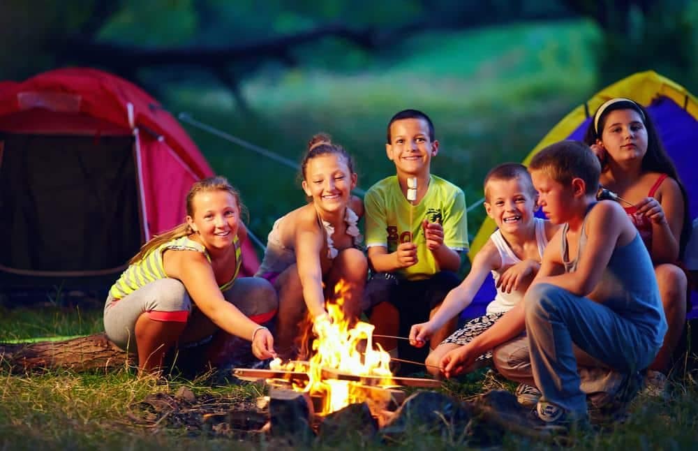 A group of kids sitting around a campfire at Riverview Ridge Campground.