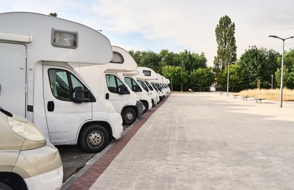 A row of white RVs parked next to each other at a used motorhome sales event in the UK.