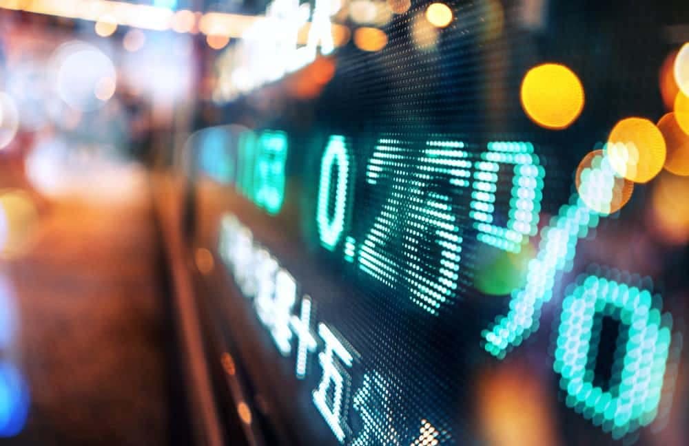 A blurry image of a stock market display showing signs of potential March interest rate hike.