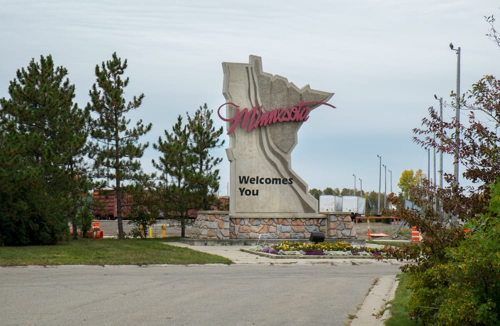 An expansive sign welcoming visitors to Minnesota, located near an RV Park.